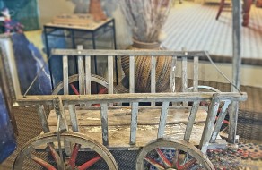 A primitive HAY WAGON with wooden wheels.